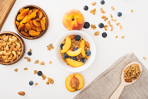 top view of delicious granola with nuts, peach, blueberry and dried apricots isolated on white