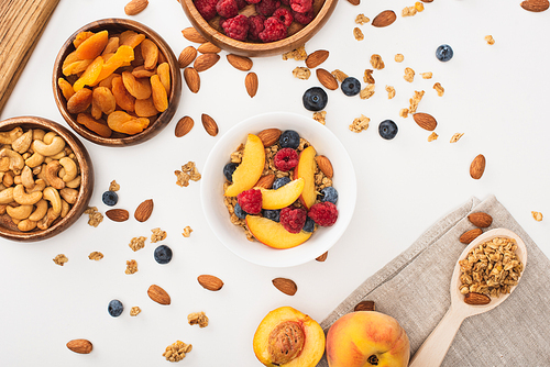 top view of delicious granola with nuts, raspberry, peach, blueberry and dried apricots isolated on white