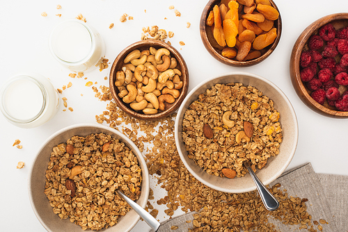 top view of delicious granola with nuts, raspberry, yogurt and dried apricots isolated on white