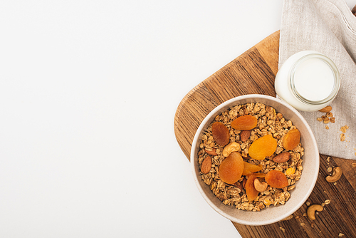 top view of delicious granola with nuts, yogurt and dried apricots isolated on white