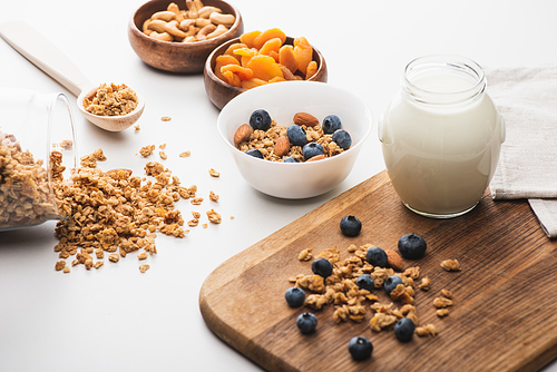 delicious granola with yogurt, nuts,dried apricots and blueberry on white background