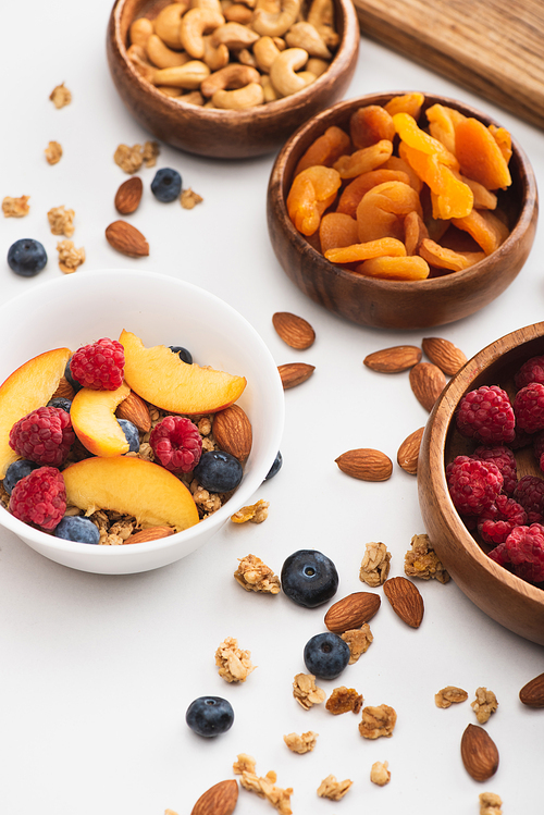 delicious granola with nuts and fruits on white background