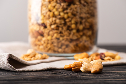 blurred delicious granola in glass gar on napkin and nuts