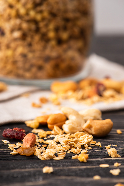 blurred delicious granola in glass gar on napkin and nuts