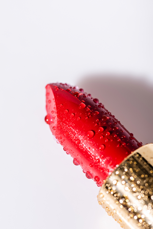 close up view of red wet lipstick on white background