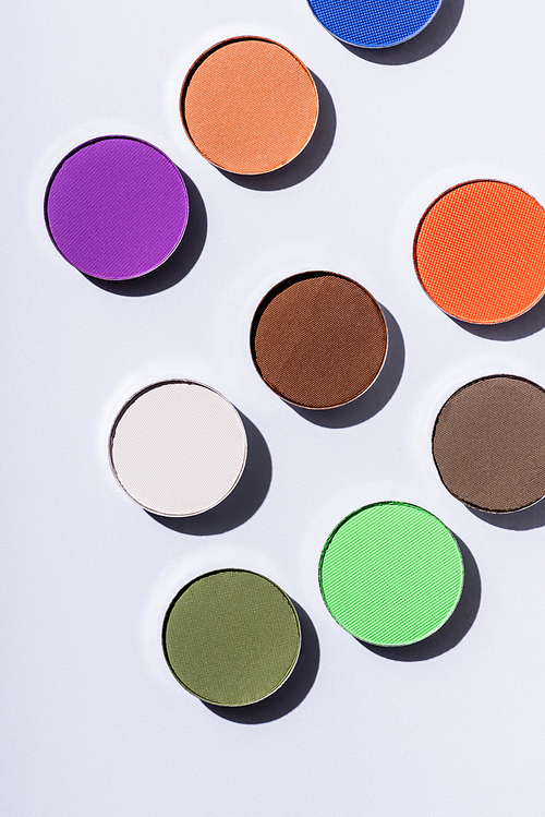 top view of multicolored eyeshadow on white background