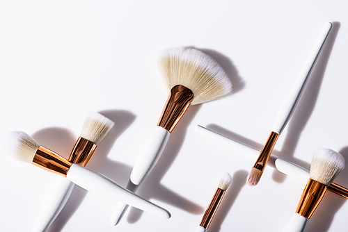 flat lay with cosmetic brushes set on white background with copy space