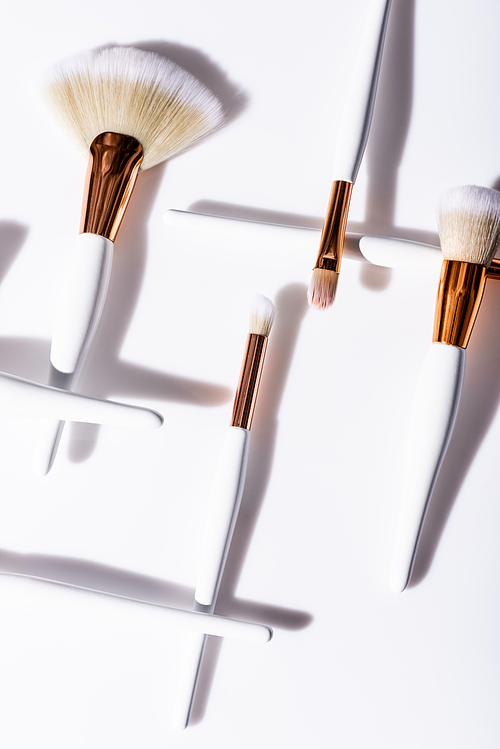 flat lay with cosmetic brushes set on white background