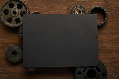 top view of vintage black paper and gears on wooden table