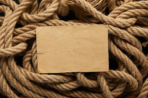 top view of vintage blank paper and rope on black background