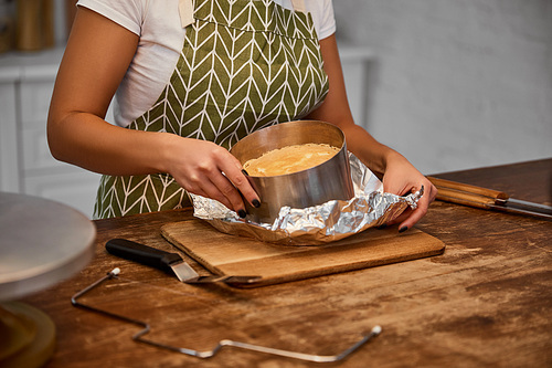 Partial view of confectioner doing form of cake with cake mold