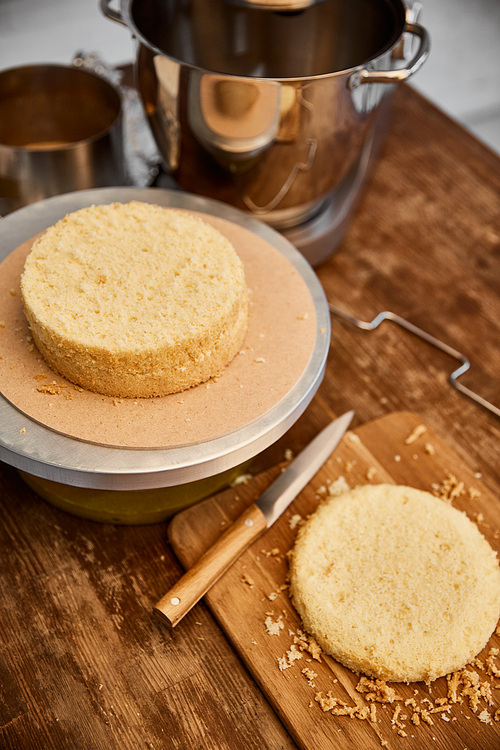 Table with cooking utensils and sponge cake in kitchen