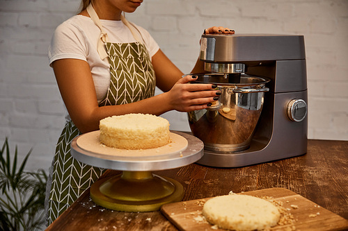 Cropped view of confectioner mixing dough in dough mixer