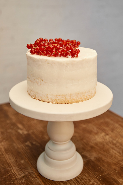 Tasty biscuit with ripe bunches of redcurrant on cake stand