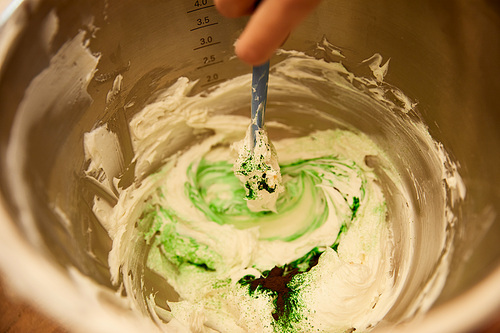 Cropped view of confectioner mixing sweet cream in bowl