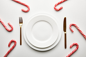 top view of festive Christmas table setting on white background with candies