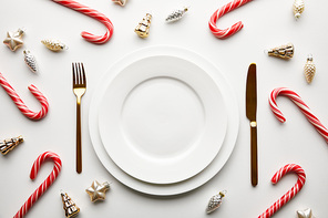 top view of Christmas table setting on white background with festive decoration and candies
