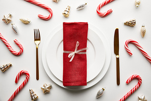 top view of Christmas table setting on white background with festive decoration and candies