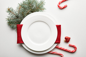 top view of festive Christmas table setting on white background with pine branch and candies
