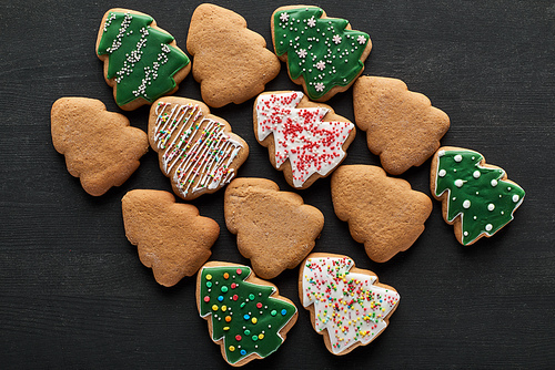 flat lay with delicious Christmas tree cookies on black background