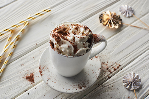 Christmas cacao with cacao powder and whipped cream on white wooden table with decoration