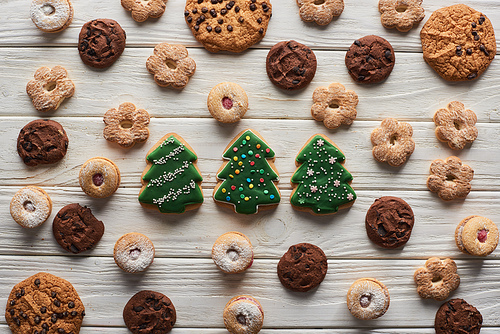 top view of Christmas tree cookies on wooden white table