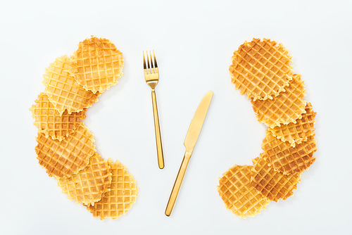 top view of cutlery rounded by waffles on white
