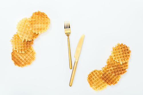 top view of waffles and golden cutlery in middle isolated on white