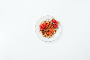 top view of plate with strawberries on waffle on plate on white