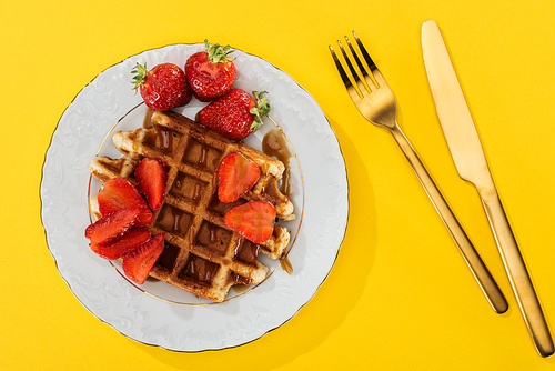 top view of plate with tasty waffle for breakfast on yellow