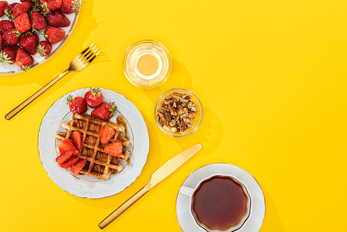 top view of served breakfast with fresh strawberries on yellow