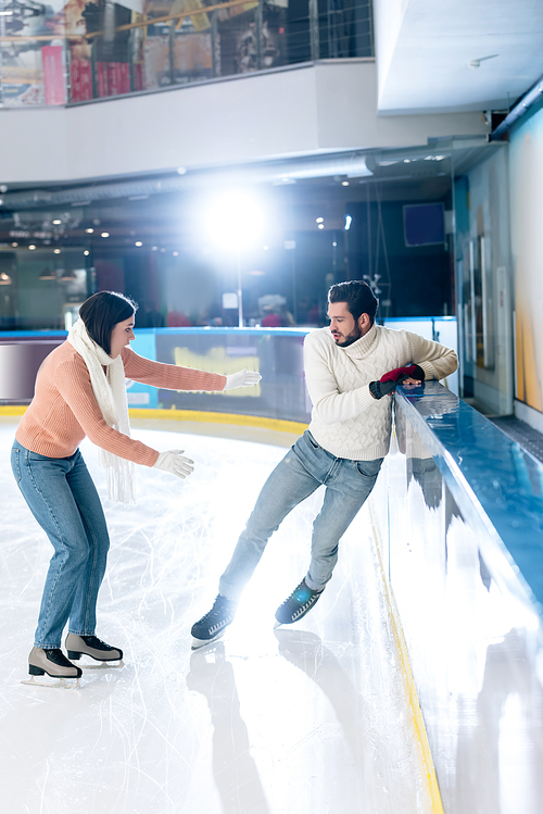 worried woman and man falling on skating rink