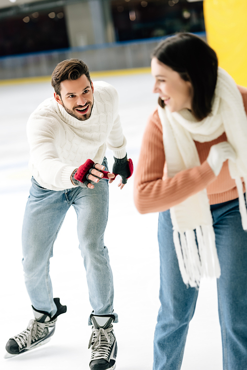 excited young couple having fun while skating on rink