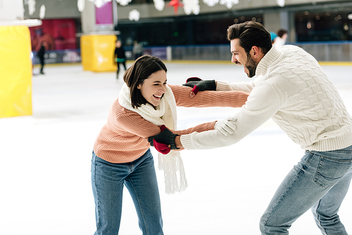 beautiful young couple having fun on skating rink