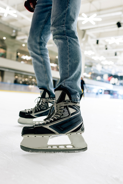 cropped view of man in skates standing on skating rink