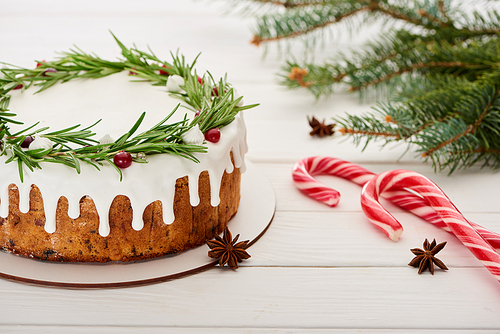 on white wooden table with candy canes and spruce branches