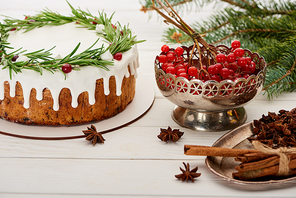 christmas pie, spices and viburnum berries on white wooden table with spruce branches