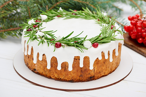 christmas pie with rosemary and viburnum berries on white wooden table with spruce branches