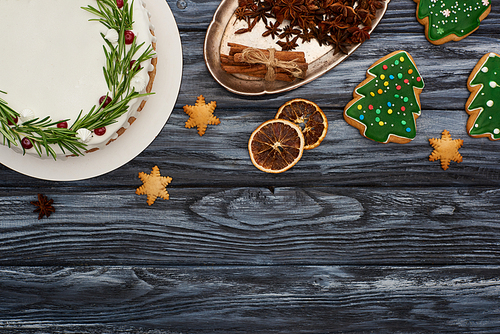 top view of christmas pie, spices and cookies on dark wooden table