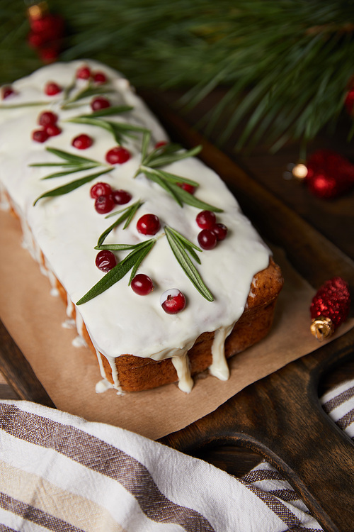 selective focus of traditional Christmas cake with cranberry near pine branch and napkin