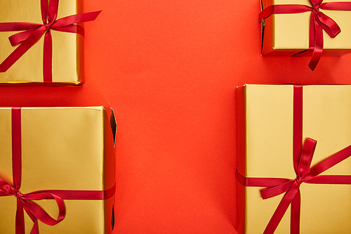 flat lay with golden gift boxes on red background with copy space