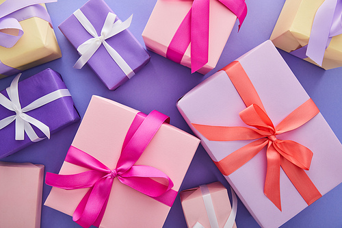 top view of colorful presents with bows on purple background