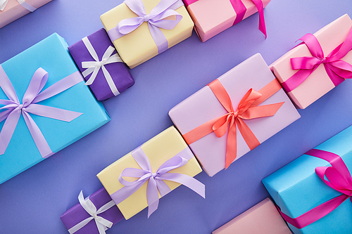 flat lay with colorful presents with bows on purple background