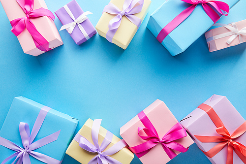 top view of colorful gift boxes on blue background with copy space