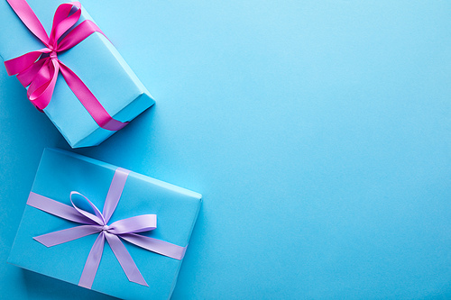 top view of colorful gift boxes on blue background with copy space
