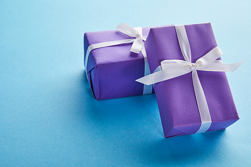 purple colorful gift boxes with ribbons and bows on blue background