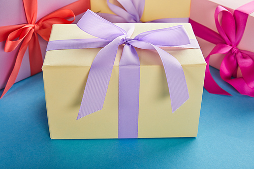 colorful gift boxes with ribbons and bows on blue background