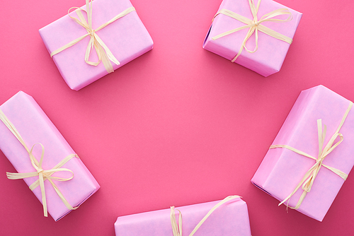 top view of gift boxes with bows on pink with copy space