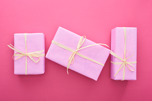 top view of wrapped presents with bows on pink