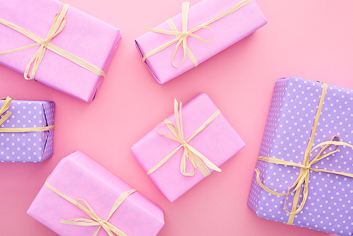 top view of colorful gift boxes with bows isolated on pink